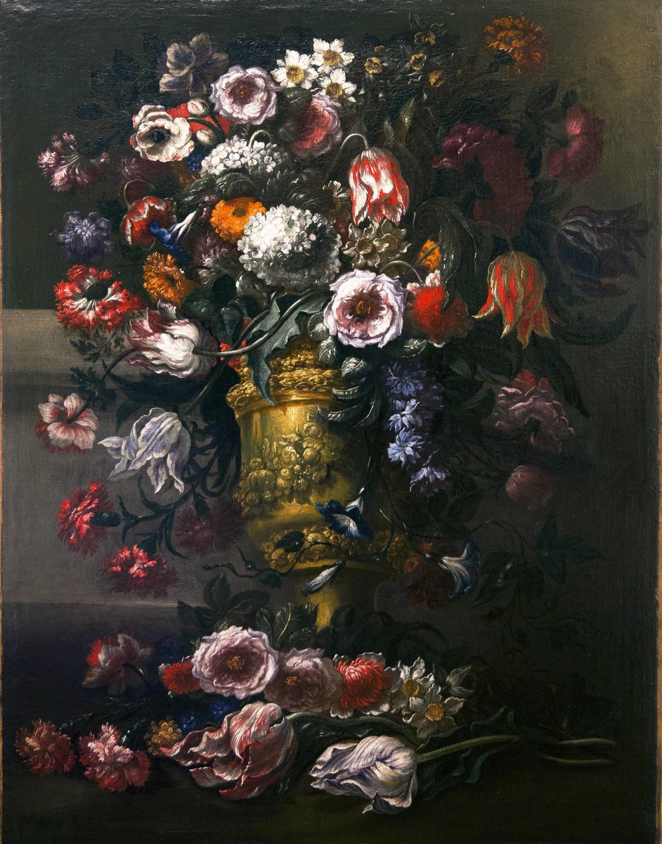 Superbe composition florale à l'intérieur d'un vase en relief en métal doré à motifs végétaux.
