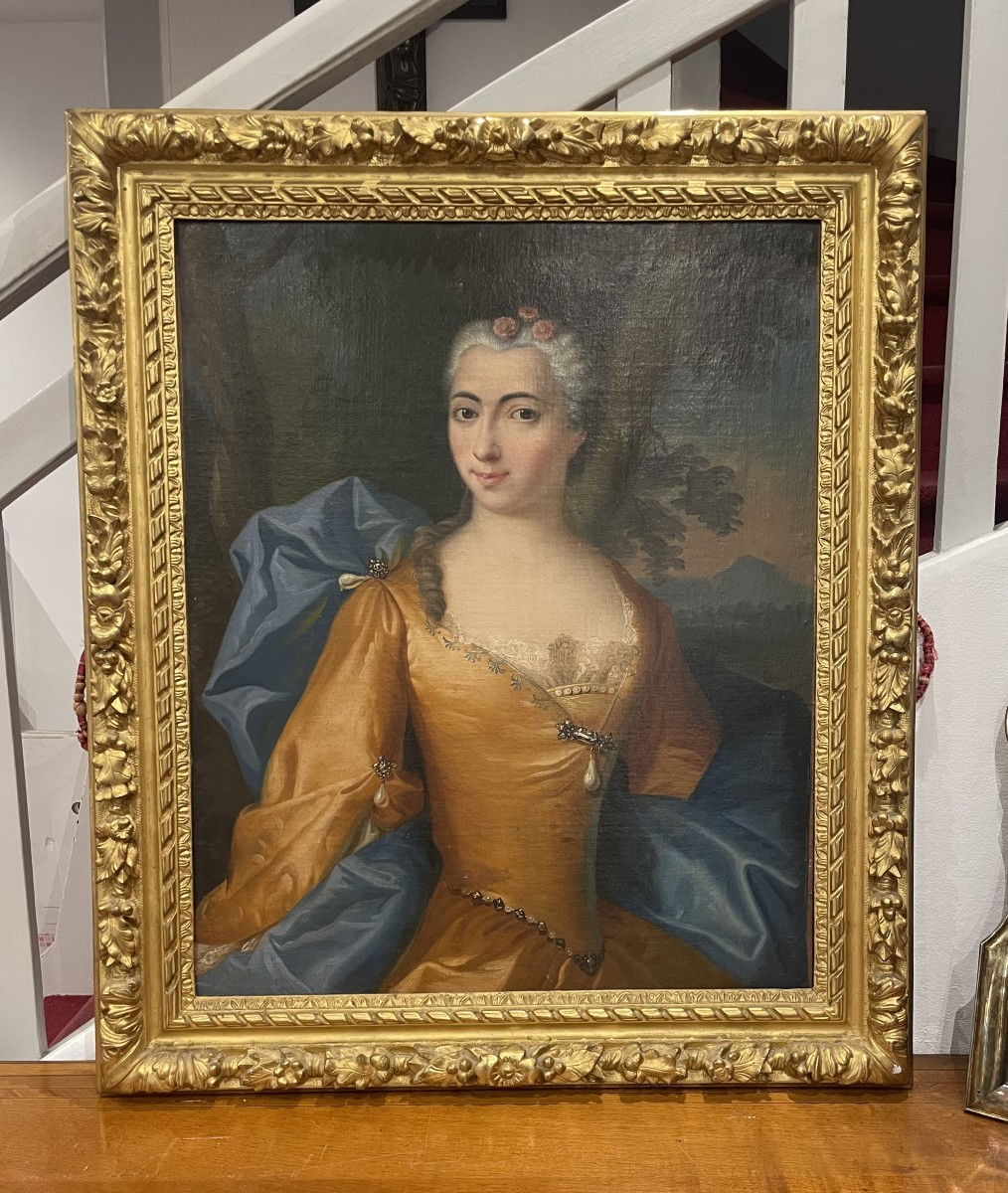 French School Of The 18th Century Portrait Of A Woman In A Golden Dress, Against A Landscape Background