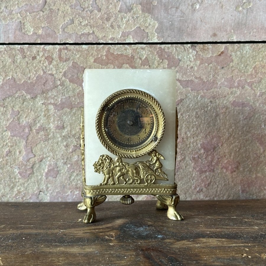 Petite pendule de table en albâtre et bronze. XIXᵉ siècle.