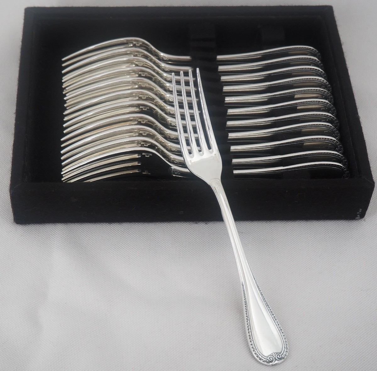 Christofle modèle Malmaison, 12 fourchettes à entremets, dessert, métal argenté, 17 cm.