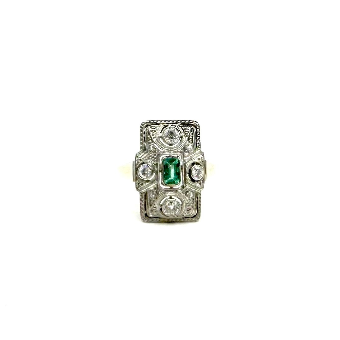 Bague Art déco en or blanc ornée de diamants et d’une émeraude.