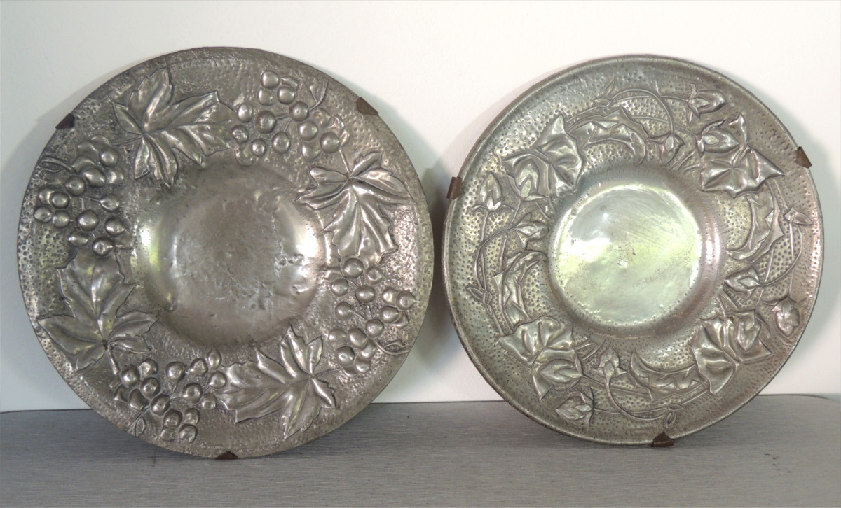 paire d'assiettes en étain repoussé martelé sur une base en métal argentée décor floral  20 ème