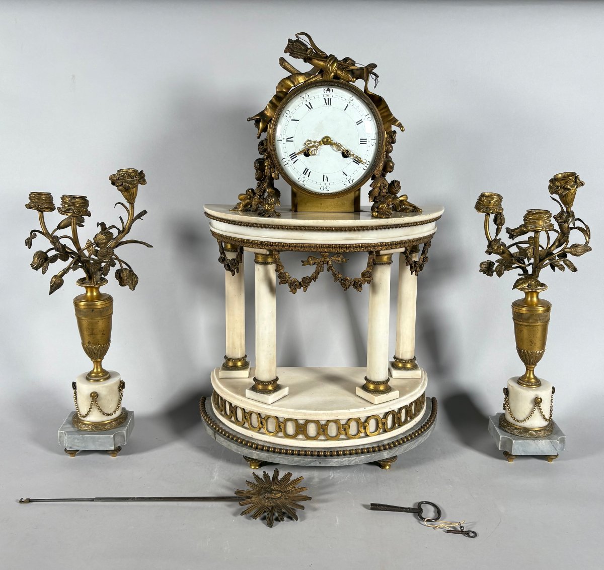 Garniture de cheminée pendule portique de style Louis XVI et candélabres aux fleurs