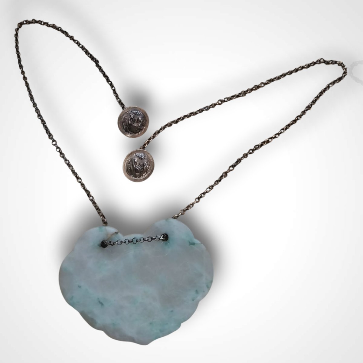 Pendentif chinois en jadéite sculptée et sa chaîne à deux boutons en argent, XXe