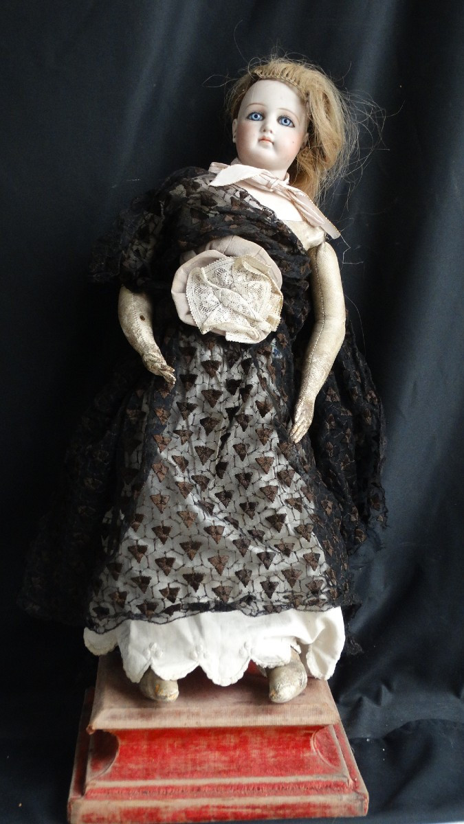 Poupée à tête porcelaine bouche fermée et corps en peau