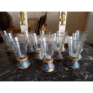 Vers 1880 : 12 verres à  eau de vie en verre taillé, pieds en bronze émaillé 