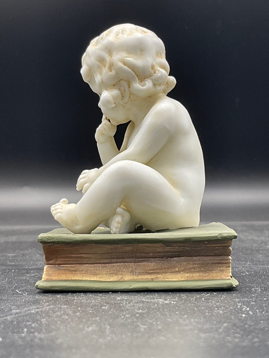 Biscuit From The Müller Factory Representing A Little Girl Sitting On A Book.-photo-1
