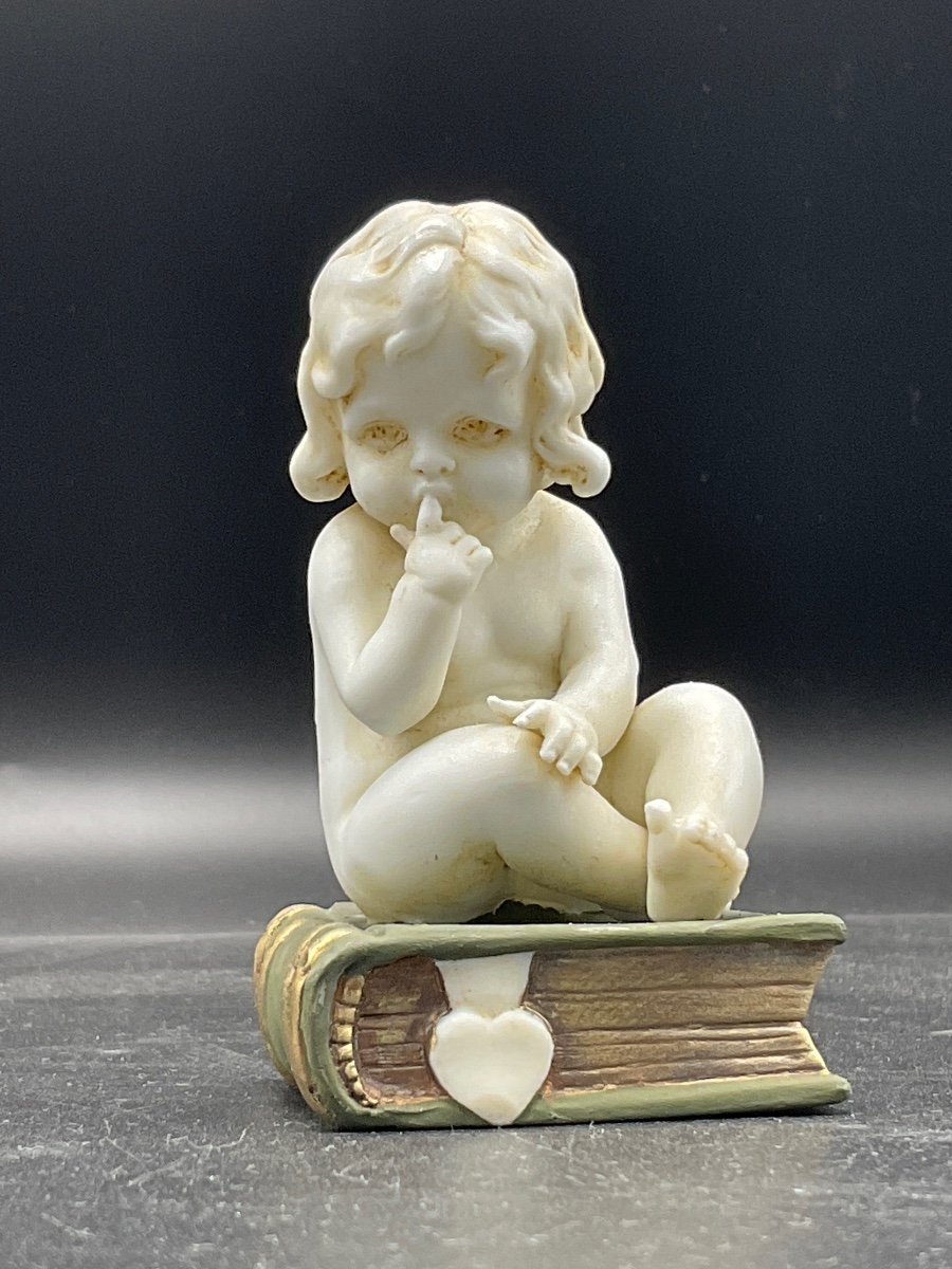 Biscuit From The Müller Factory Representing A Little Girl Sitting On A Book.