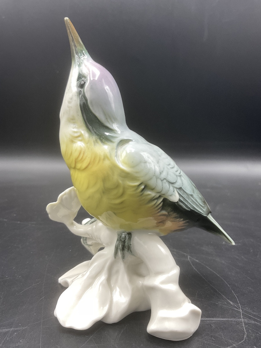 Sittelle torchepot perché sur une branche en porcelaine coloré de la manufacture de Karl Ens.