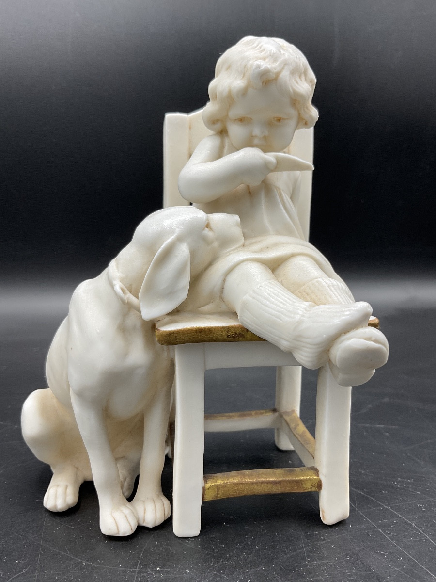 Biscuit de la manufacture Müller représentant une fillette assise sur une chaise avec un chien.