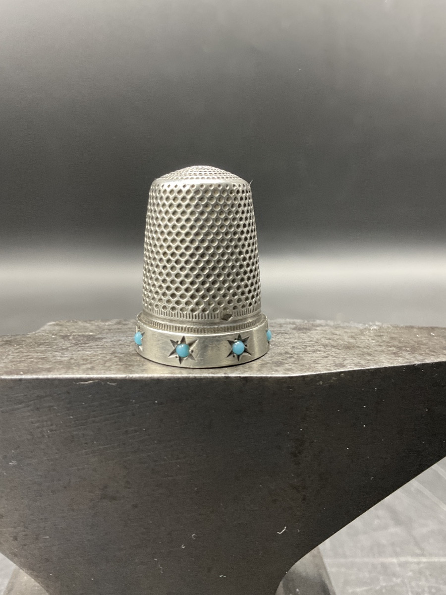 Dé à coudre en argent massif orné d'une frise étoilée avec des cabochons sertis de turquoise.