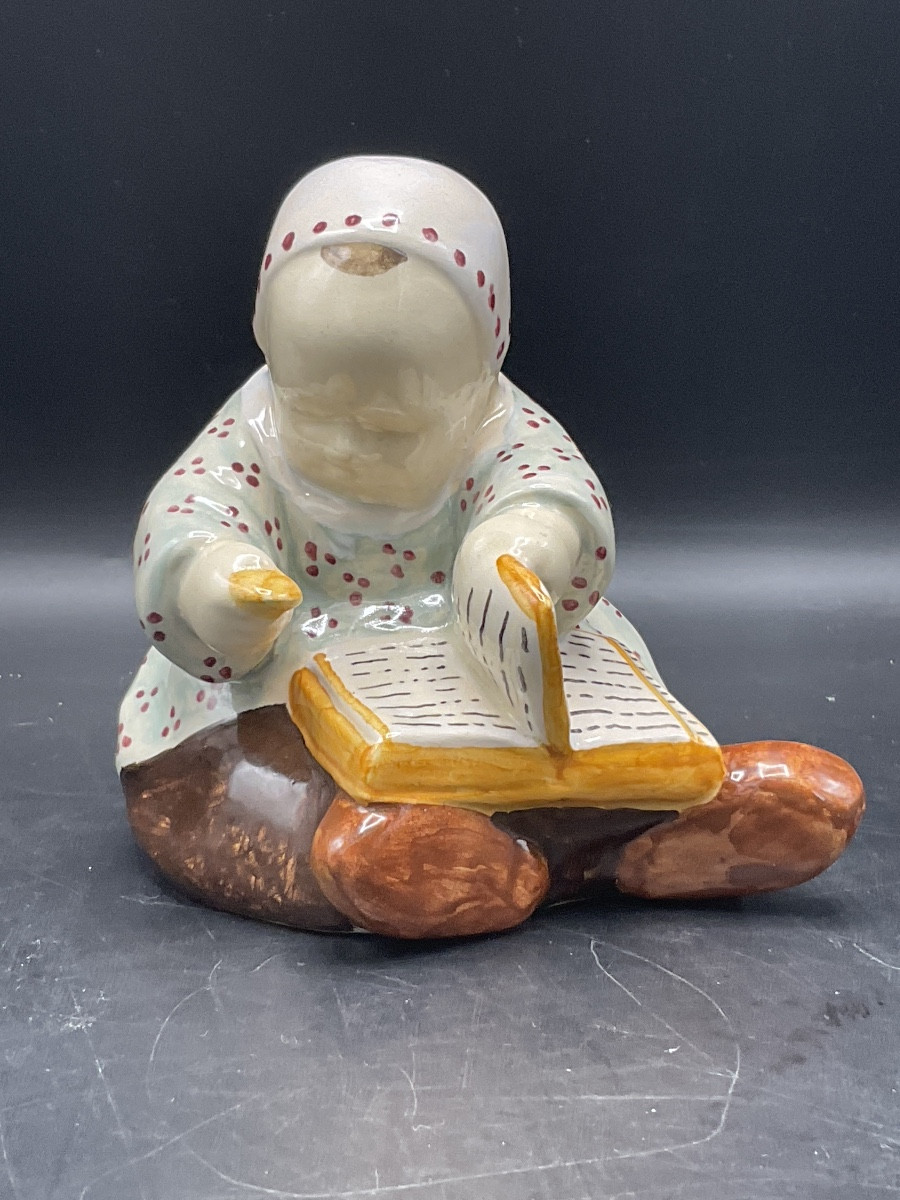 Berthe Savigny bébé en faïence coloré assis avec un livre et un biscuit manufacture HB Quimper