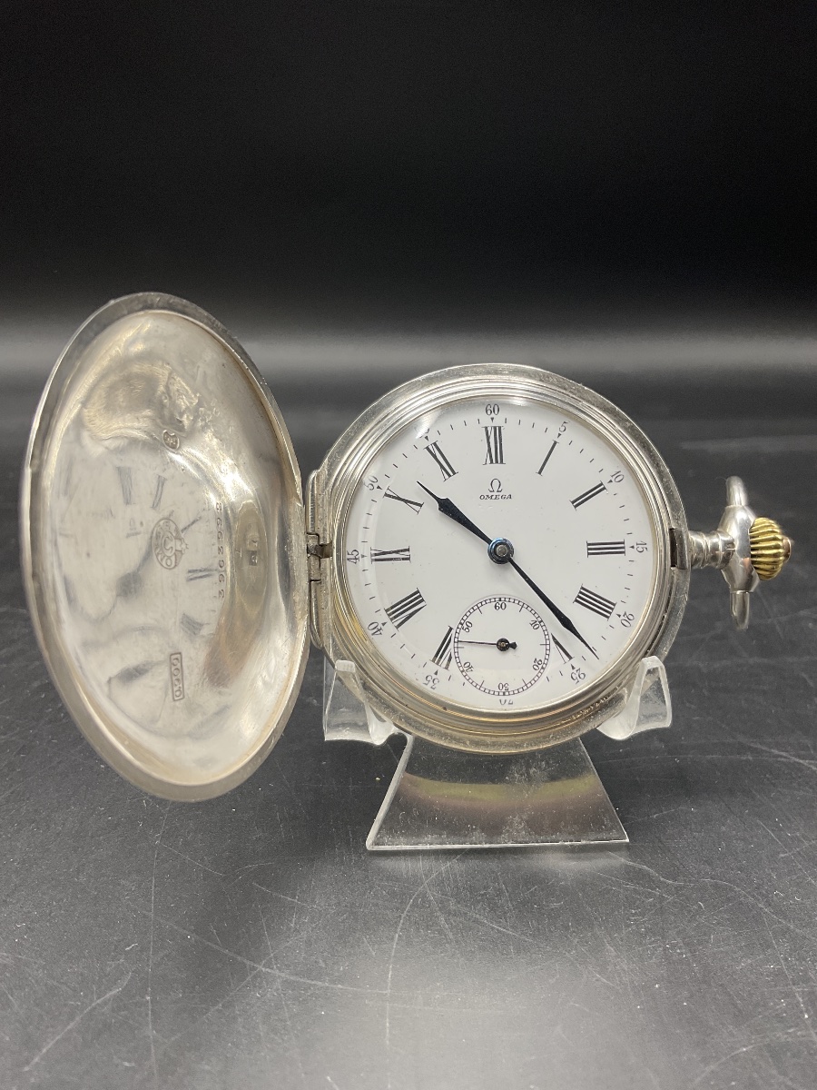 – Montre à gousset ou de poche savonnette de marque Omega en argent à décor de rinceaux fleuris