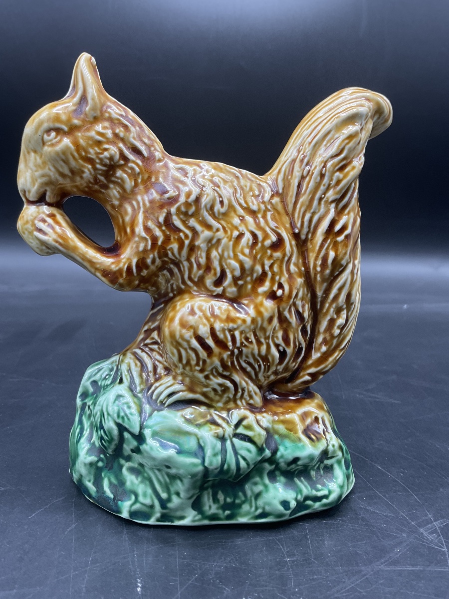 Tirelire en barbotine polychrome de la manufacture Onnaing représentant un écureuil.