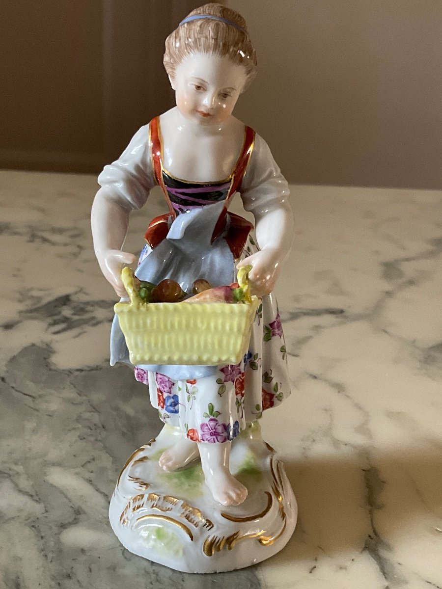 Polychrome Meissen Porcelain Figurine Representing A Young Girl Holding A Basket Of Vegetables.