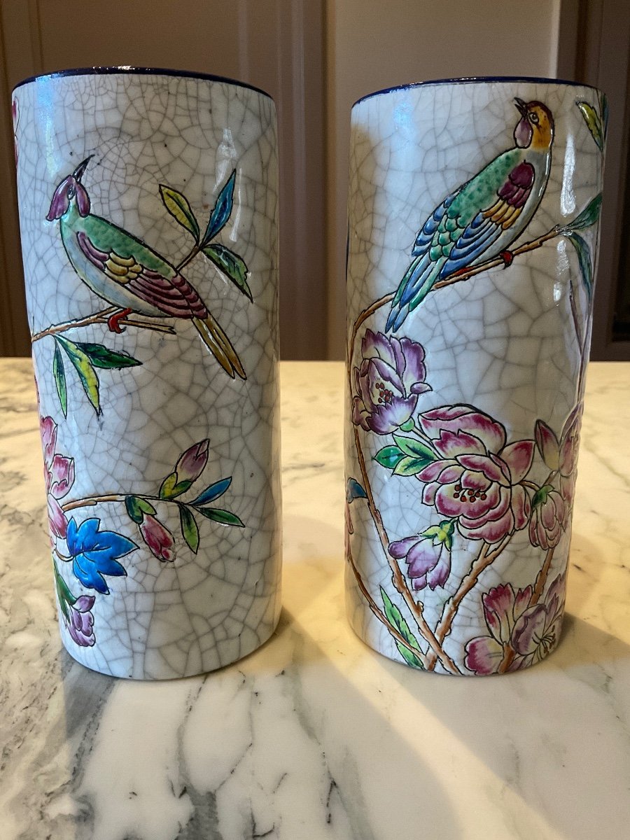 Pair Of Cylindrical Polychrome Vases In Longwy Enamels Decorated With Birds Perched On A Branch Of Flowering Foliage.