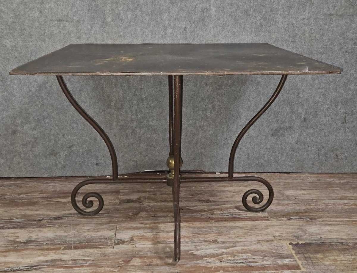 Wrought Iron Table With Sculptural Base, Adorned With Scrolls And A Central Brass Element. -photo-1