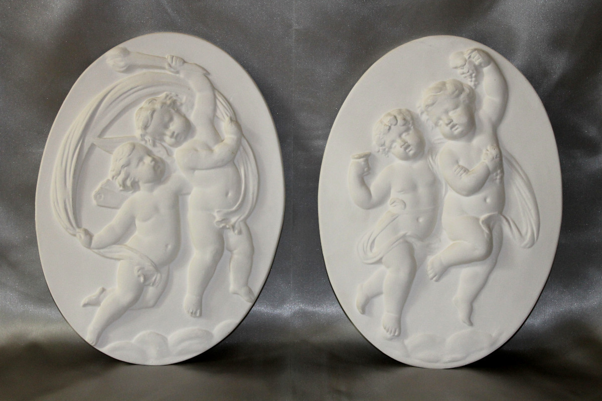Paire de bas reliefs en plâtre à décor d'angelots de style Louis XVI époque 20ème