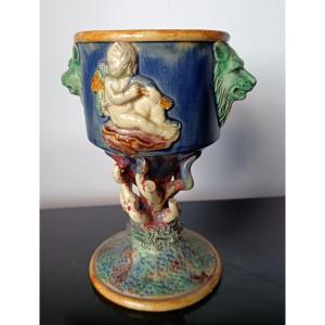 Thomas SERGENT (1830 - 1890) Barbotine en forme de Calice sur pied Décor en relief d’un angelot