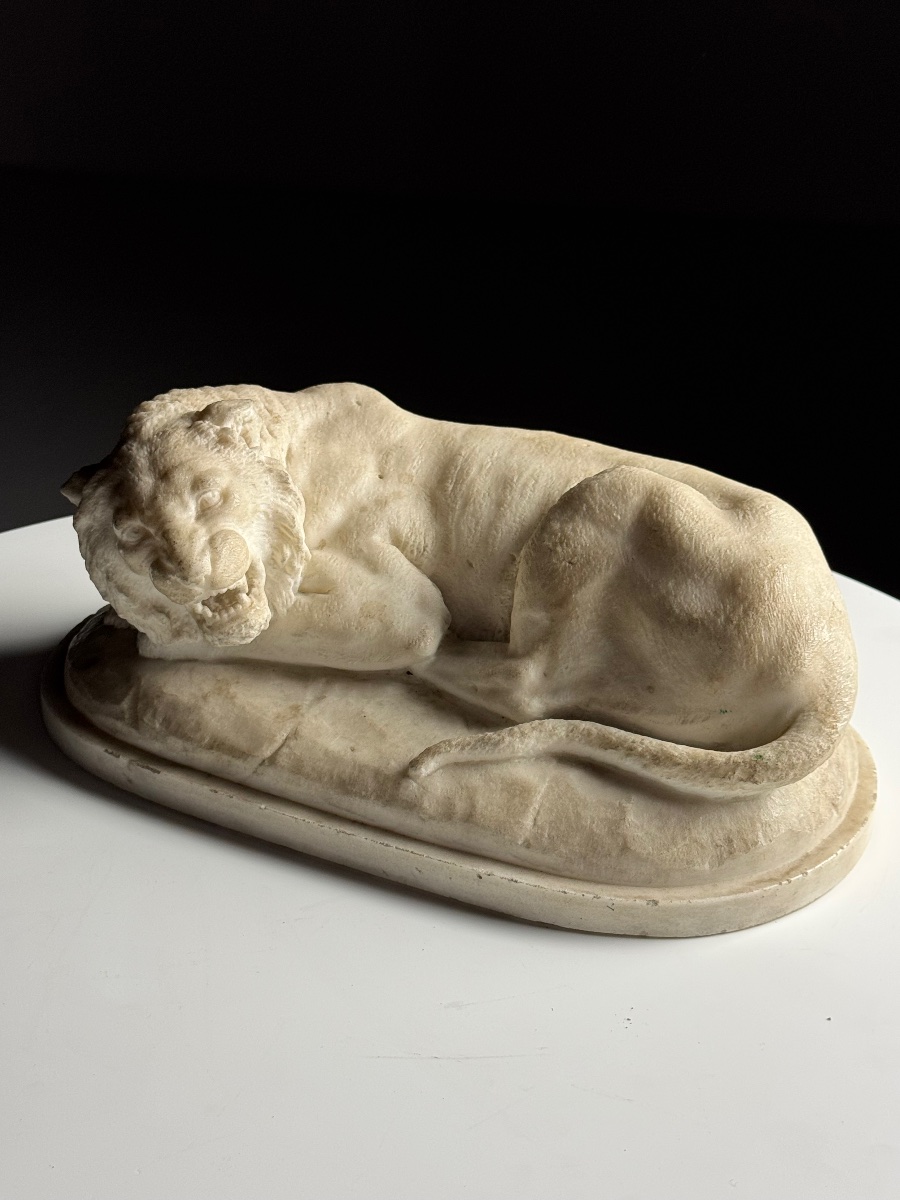 Statue en marbre moulé représentant un lion couché 