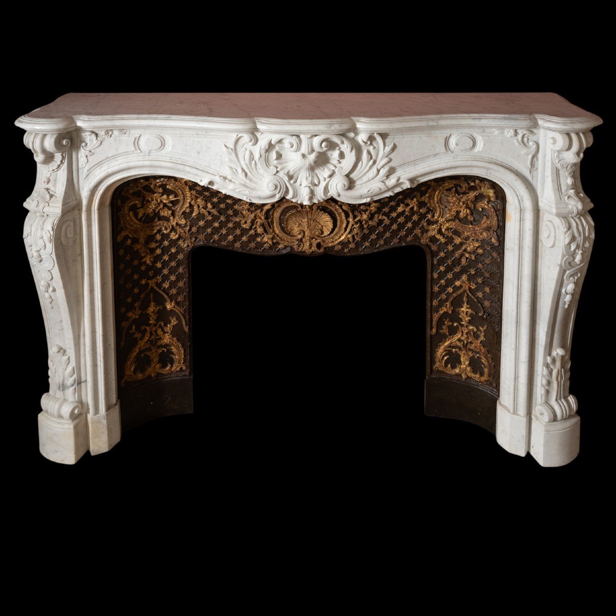 Chemin&eacute;e de style Louis XV en marbre de carrare et contre-coeur en fonte r&eacute;hauss&eacute;e d&#039;or, XIXe
