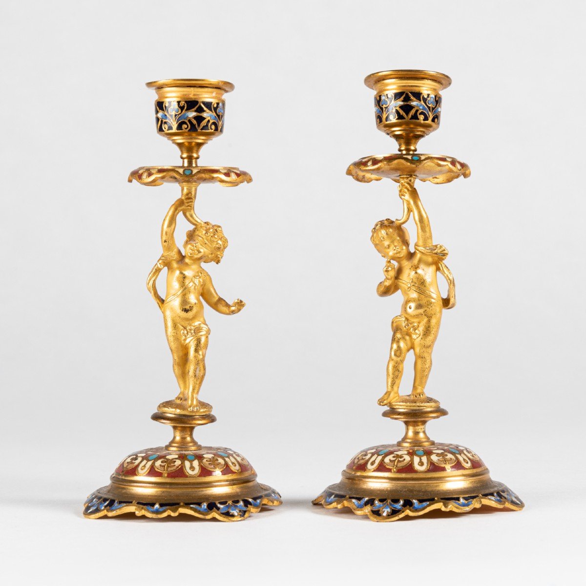 Paire de petits bougeoirs aux bébés en bronze doré et émaux cloisonnés, XIXe