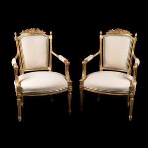 Paire de fauteuils en bois doré, garni de tissu beige, de style Louis XVI, XIXe