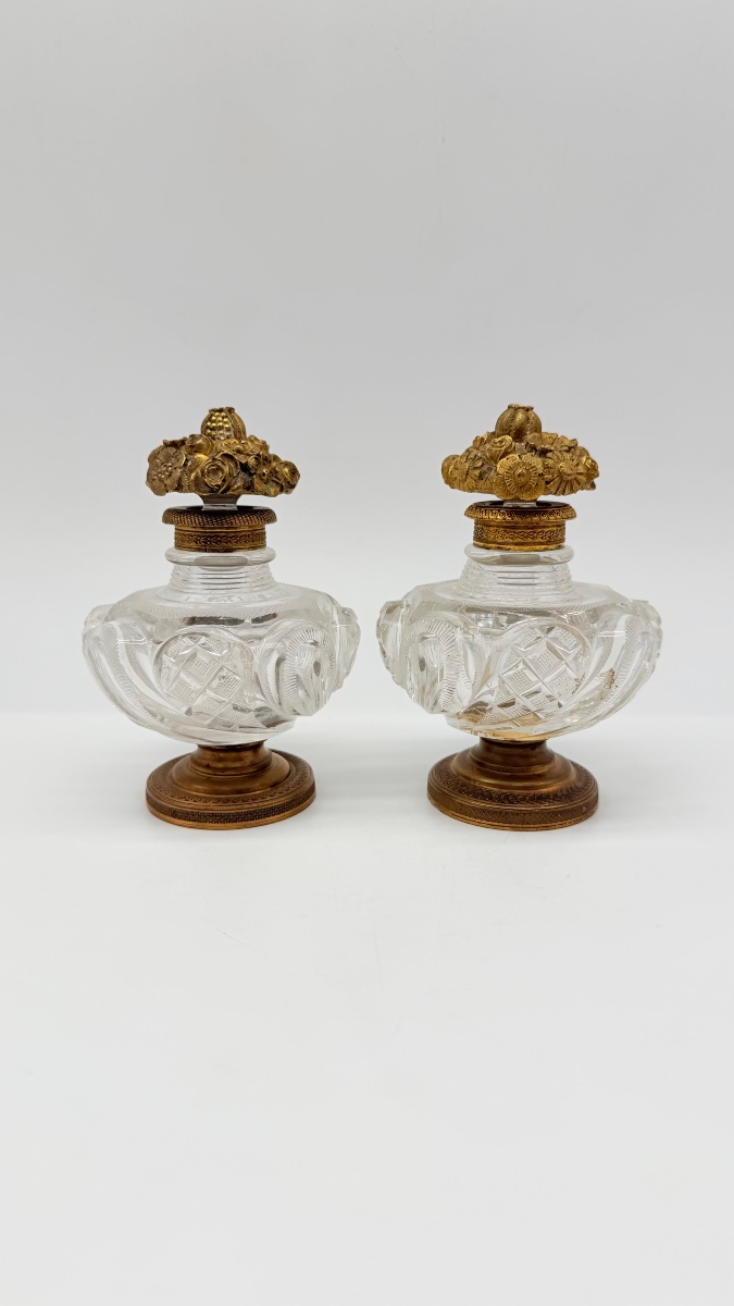 Pair Of Baccarat Perfume Bottles With A Floral Bronze Lids.
