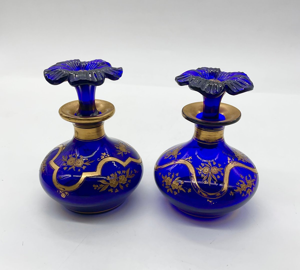 PAIRE DE FLACONS À PARFUM EN CRISTAL BLEU COBALT À DÉCOR FLORAL DORÉ ET BOUCHONS EN FLEUR
