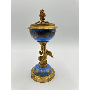 Un brûle parfum en opaline bleu-lavande sur une monture en laiton et bronze dorés à décor d'un 