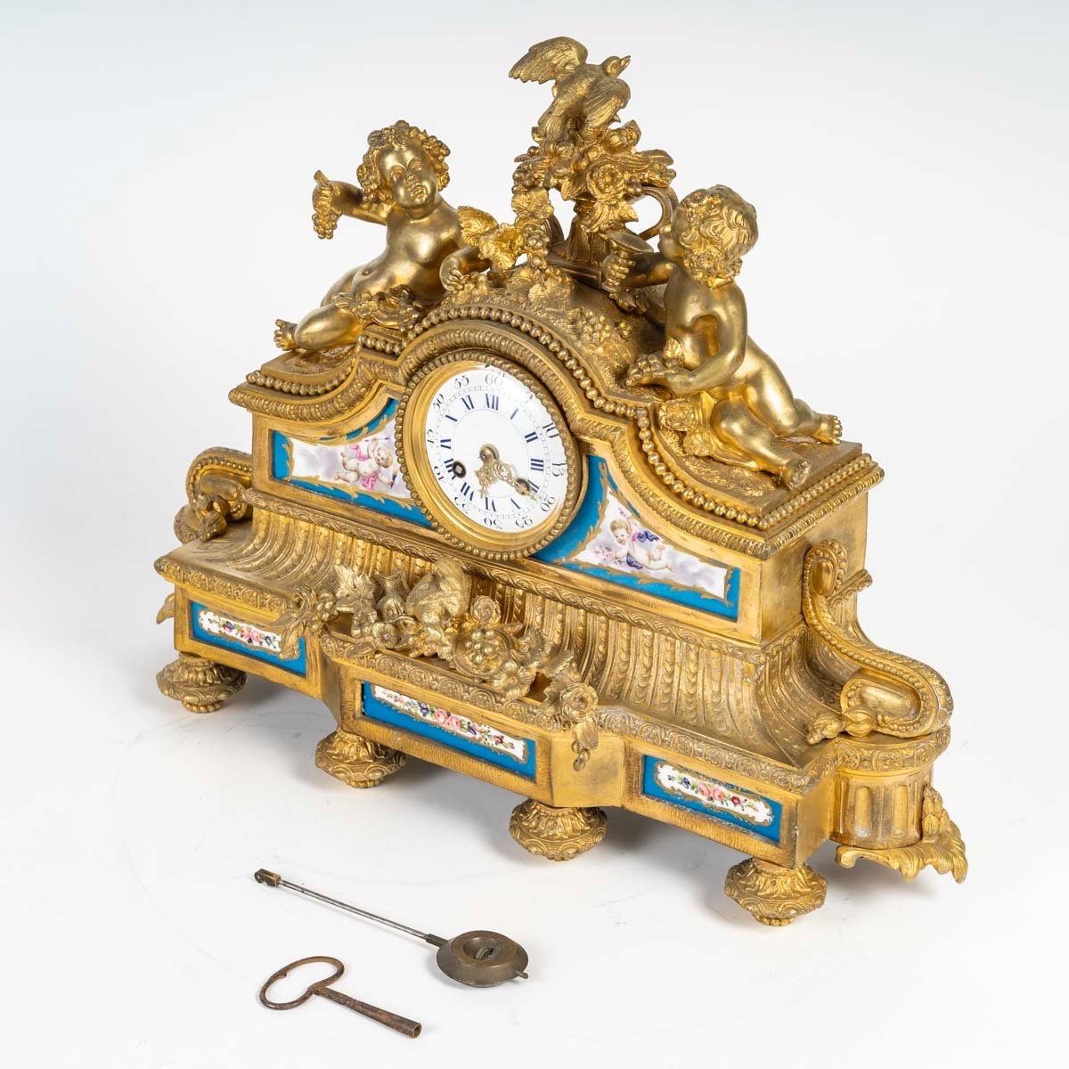 PENDULE EN BRONZE DORÉ ET PLAQUES DE PORCELAINE, 19ᵉ SIÈCLE