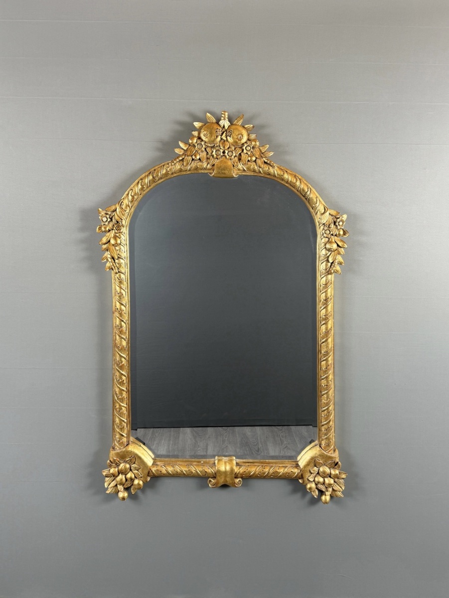 Miroir en bois sculpté et doré à décor de fruits et de fleurs, XXe siècle