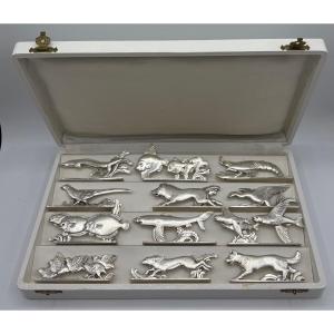UN COFFRET DE DOUZE PORTES COUTEAUX DES ANNÉES 1930 EN MÉTAL ARGENTÉ DE CHEZ ORBRILLE