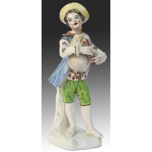 Statuette en porcelaine Un jeune garçon jouant de la cornemuse 