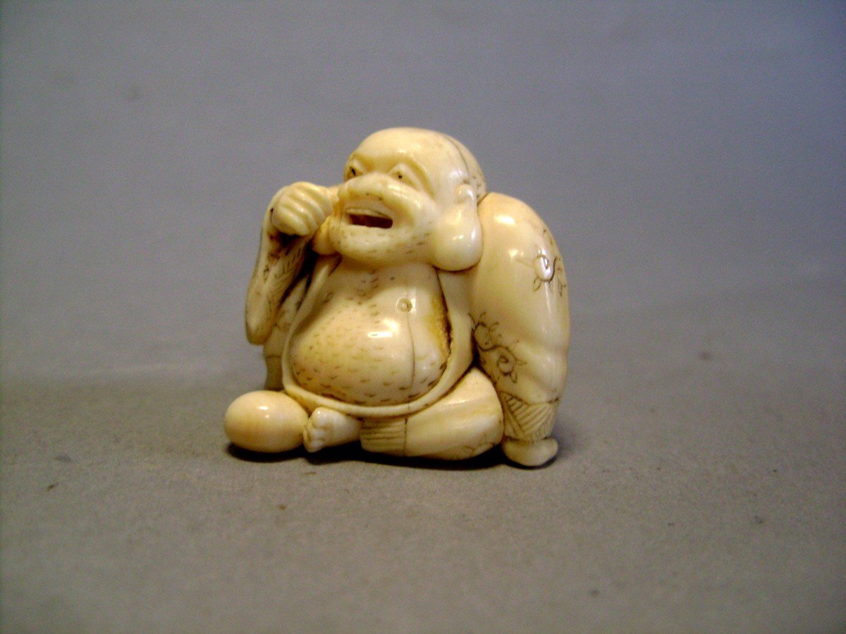 Netsuke en Ivoire. Hotei mangeant. Signé Sako, école de Kyoto, époque Meiji (1868-1912 )