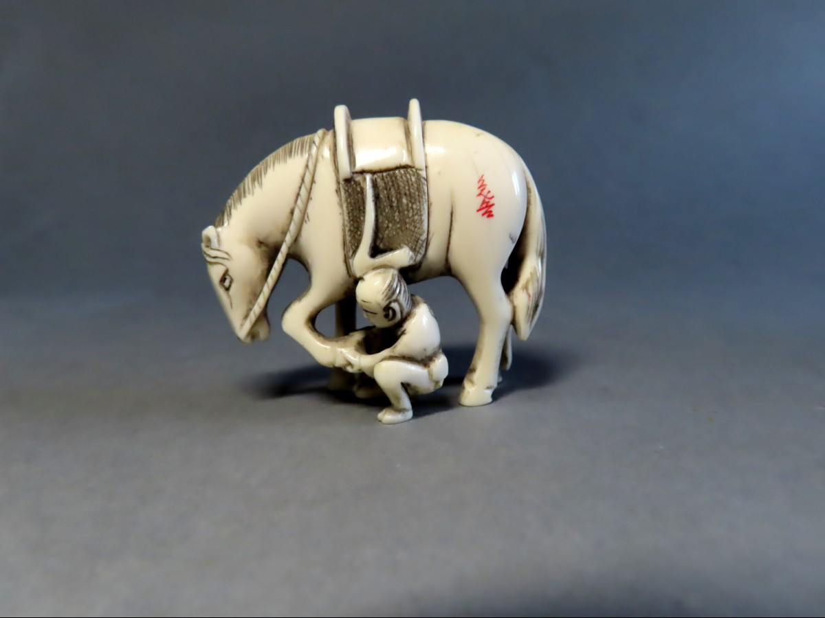 Netsuke en ivoire.  Cavalier curant un sabot. Japon époque Meiji (1868-1912 )