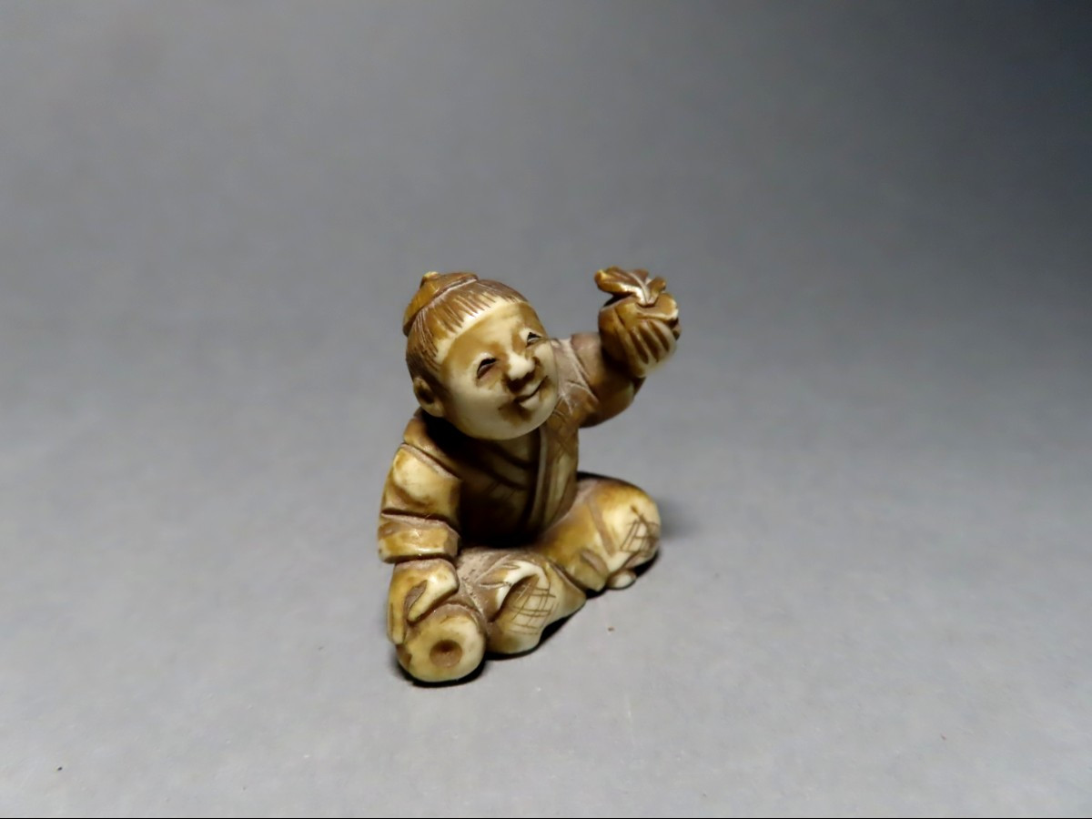 Netsuke en ivoire. Scène de rue, petit marchand de fruits. Japon époque Meiji (1868-1912 )-photo-1