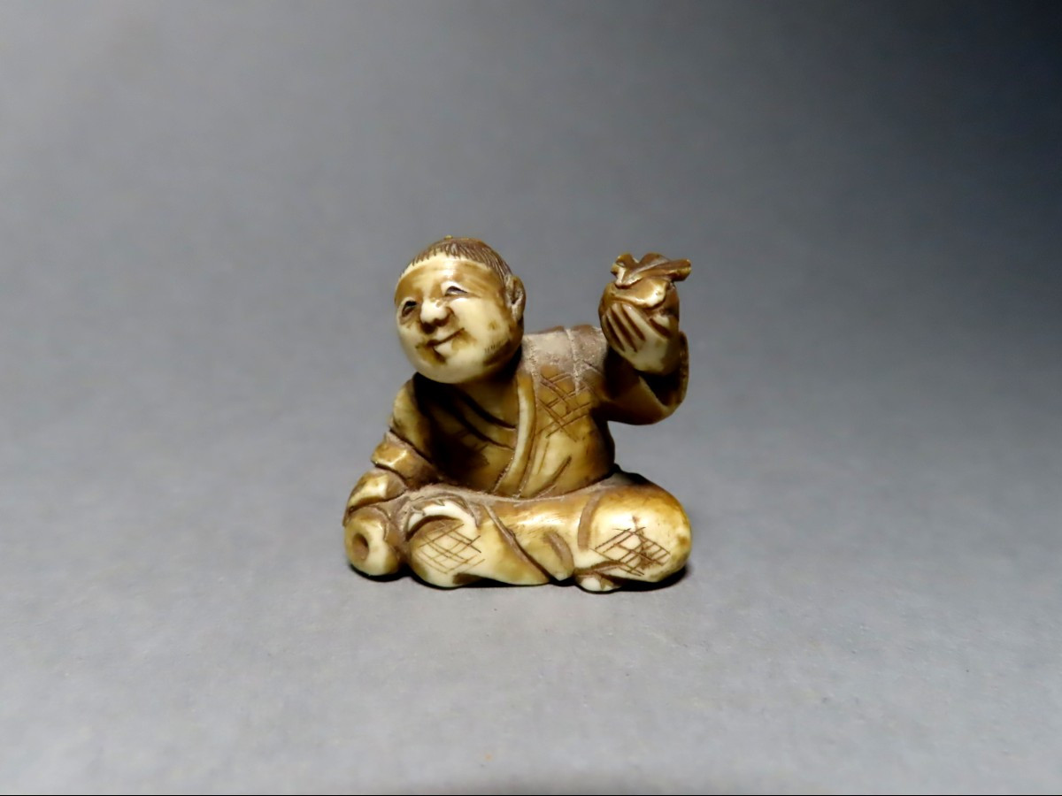 Netsuke en ivoire. Scène de rue, petit marchand de fruits. Japon époque Meiji (1868-1912 )