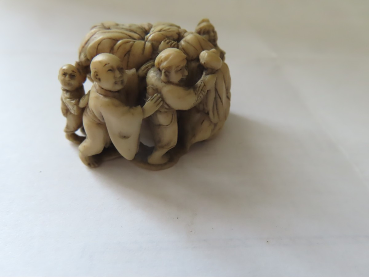 Netsuke en ivoire. Les  petits hommes au kaki. Japon époque Meiji (1868-1912 )-photo-1