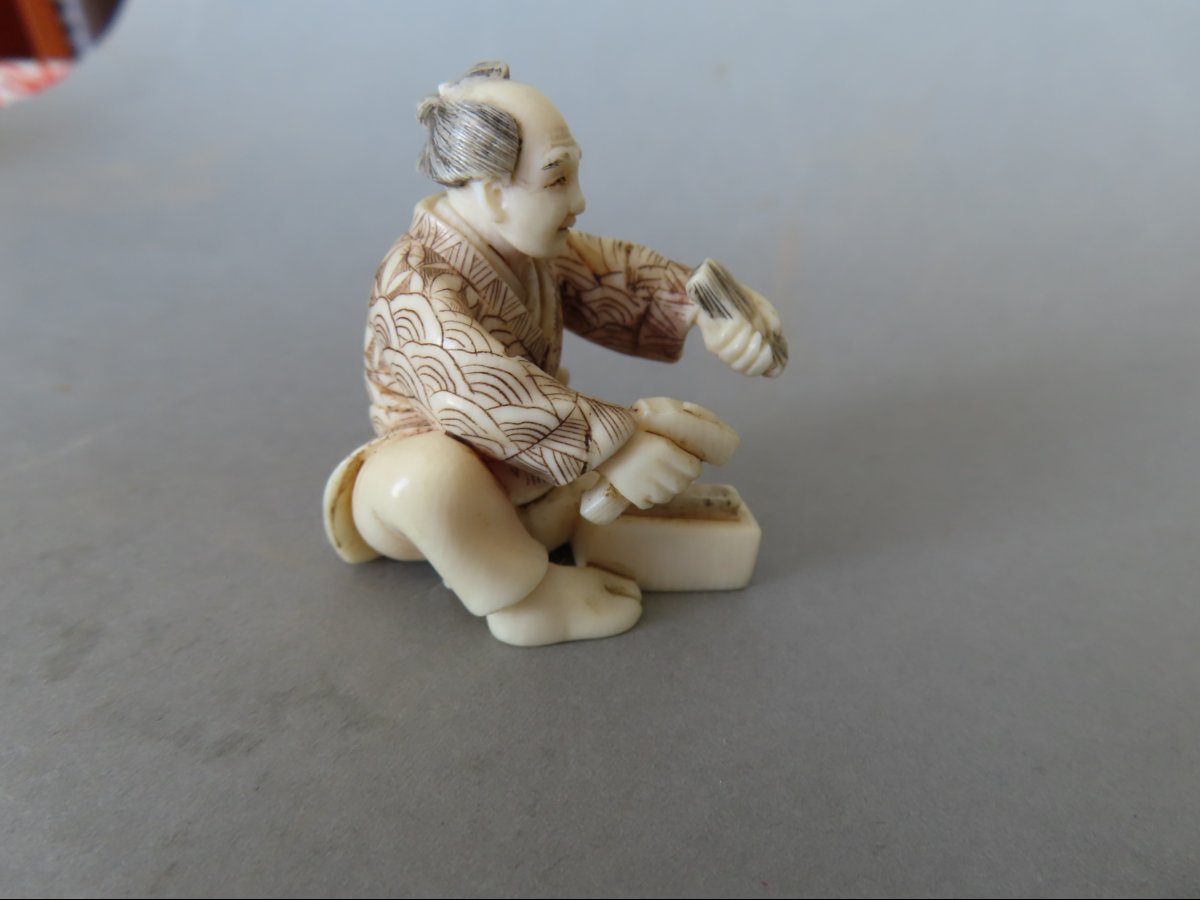 Netsuke en ivoire. Scène de rue, artisan au marteau. Japon époque Taisho (1912-1928 )-photo-1
