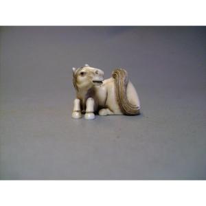 Netsuke en ivoire. Cheval couché. Signé, Japon époque Taisho.