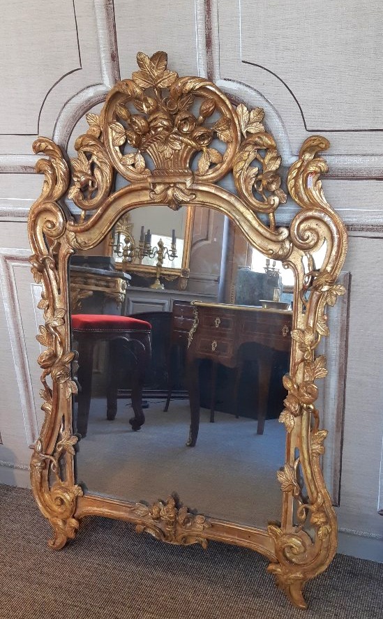 Glace en bois sculpté, doré d'époque Louis XV