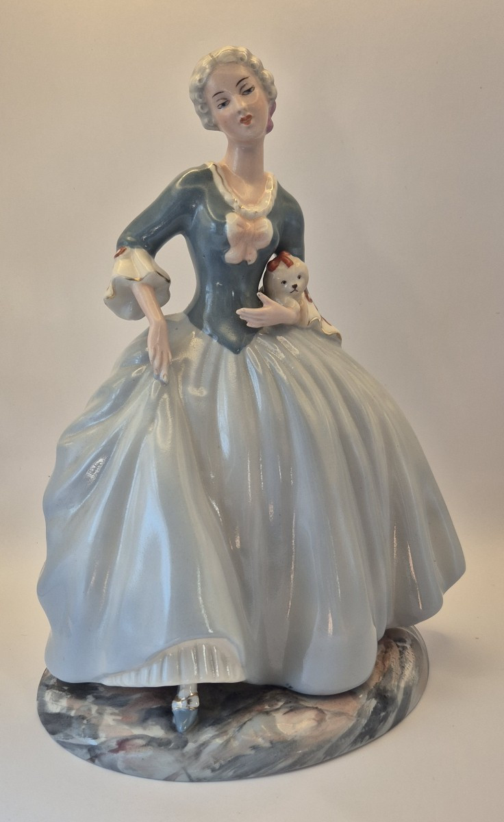 ROYAL DUX BOHEMIA, "Jeune femme à la robe à arceaux et au chien", porcelaine émaillée