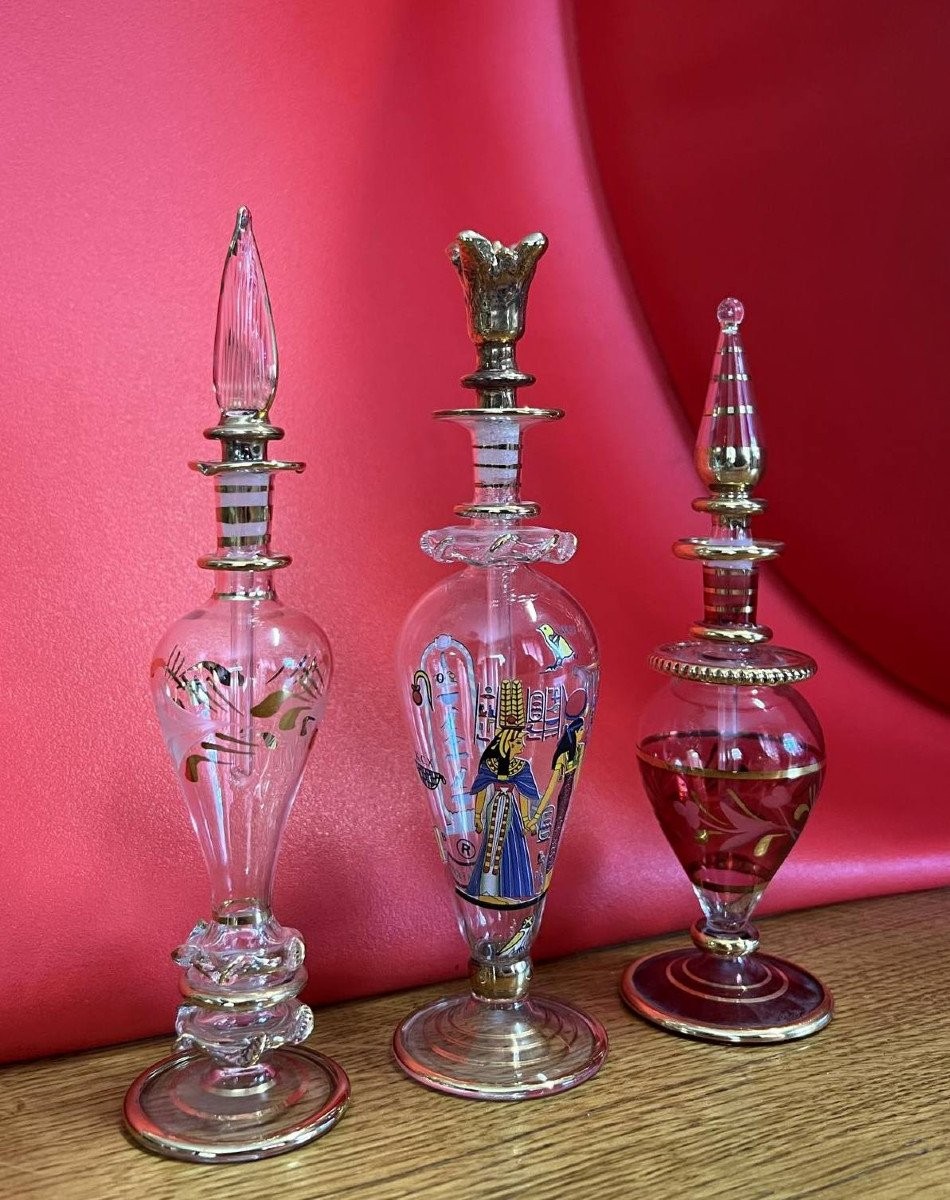 Trois flacons en verre translucide et rehauts de dorure   