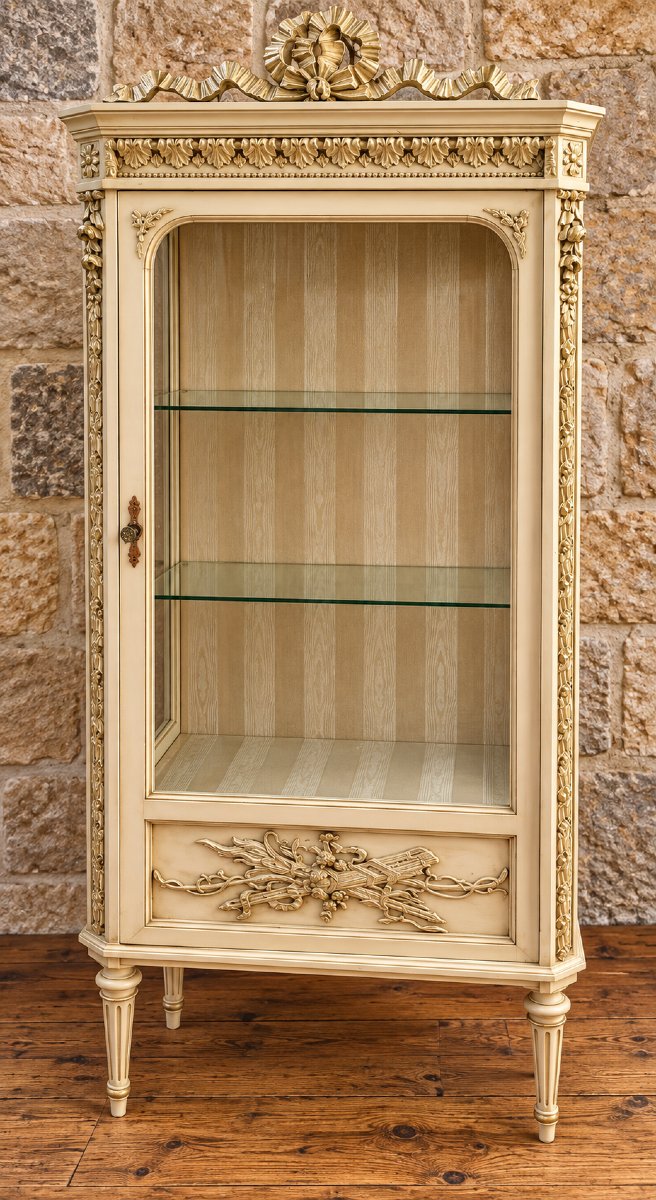 Vitrine de style Louis XVI en bois peint et doré – décor de rubans et trophées