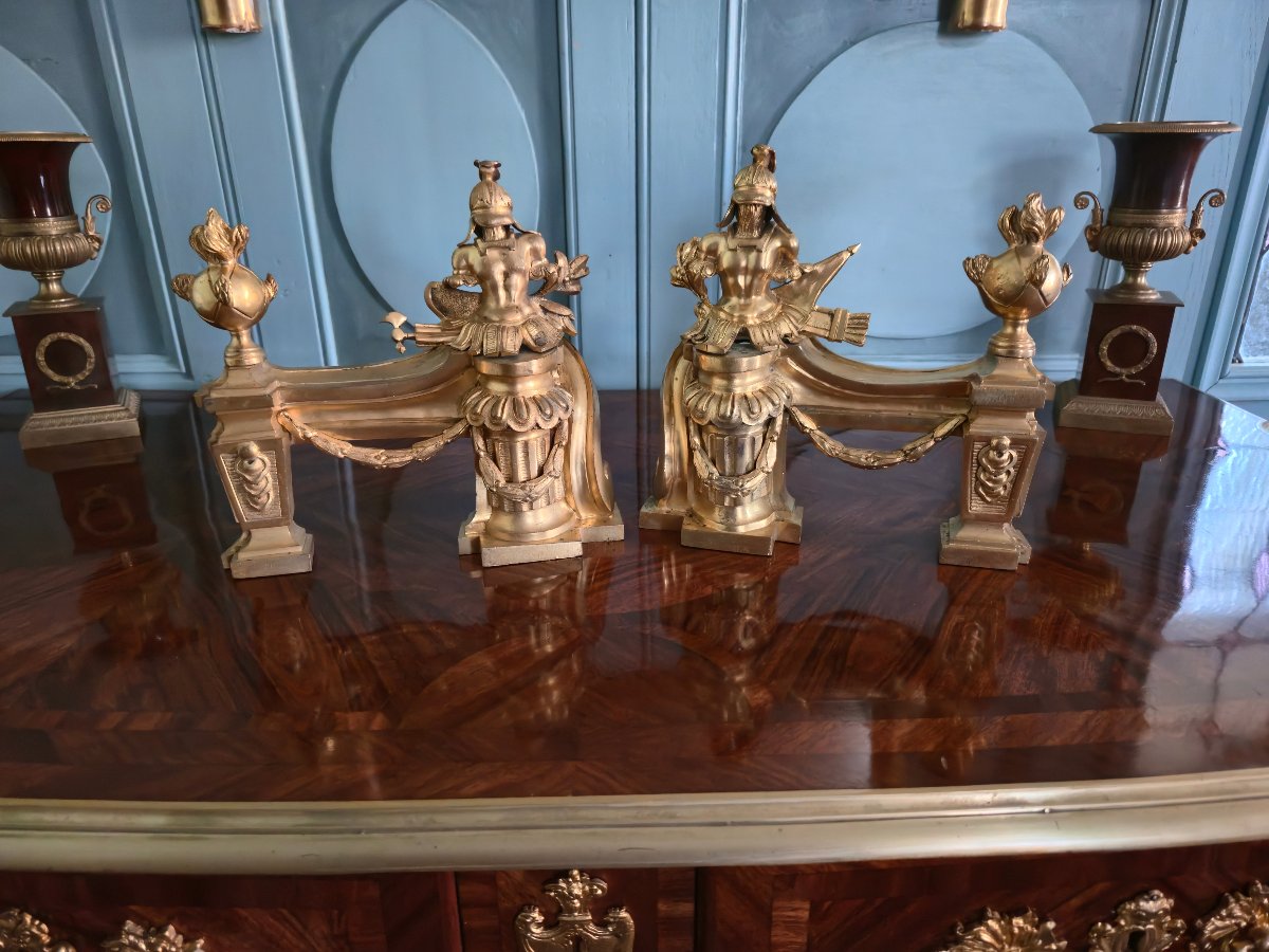 Paire de têtes de chenets aux trophées d'armes en bronze doré, transition Louis XV-Louis XVI