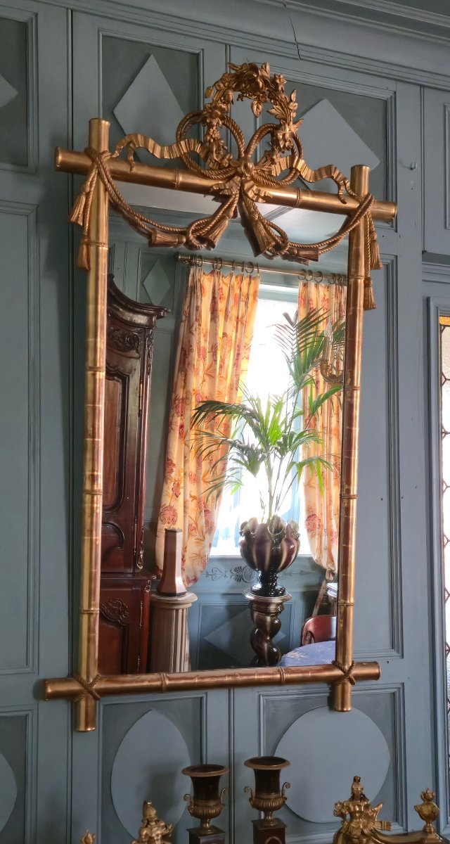 Miroir d'époque Napoléon III à l'imitation du bambou et à décor de draperies à houppes.  