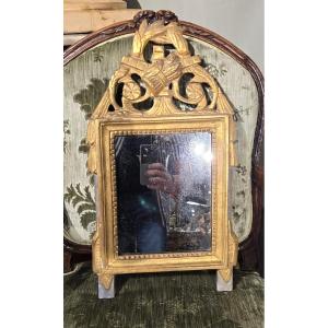 Petit miroir d'époque Louis XVI à décor champêtre en bois sculpté et doré.  