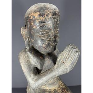 Birmanie, XIXème siècle, sculpture en bois figurant un moine bouddhiste sur un socle lotiforme.