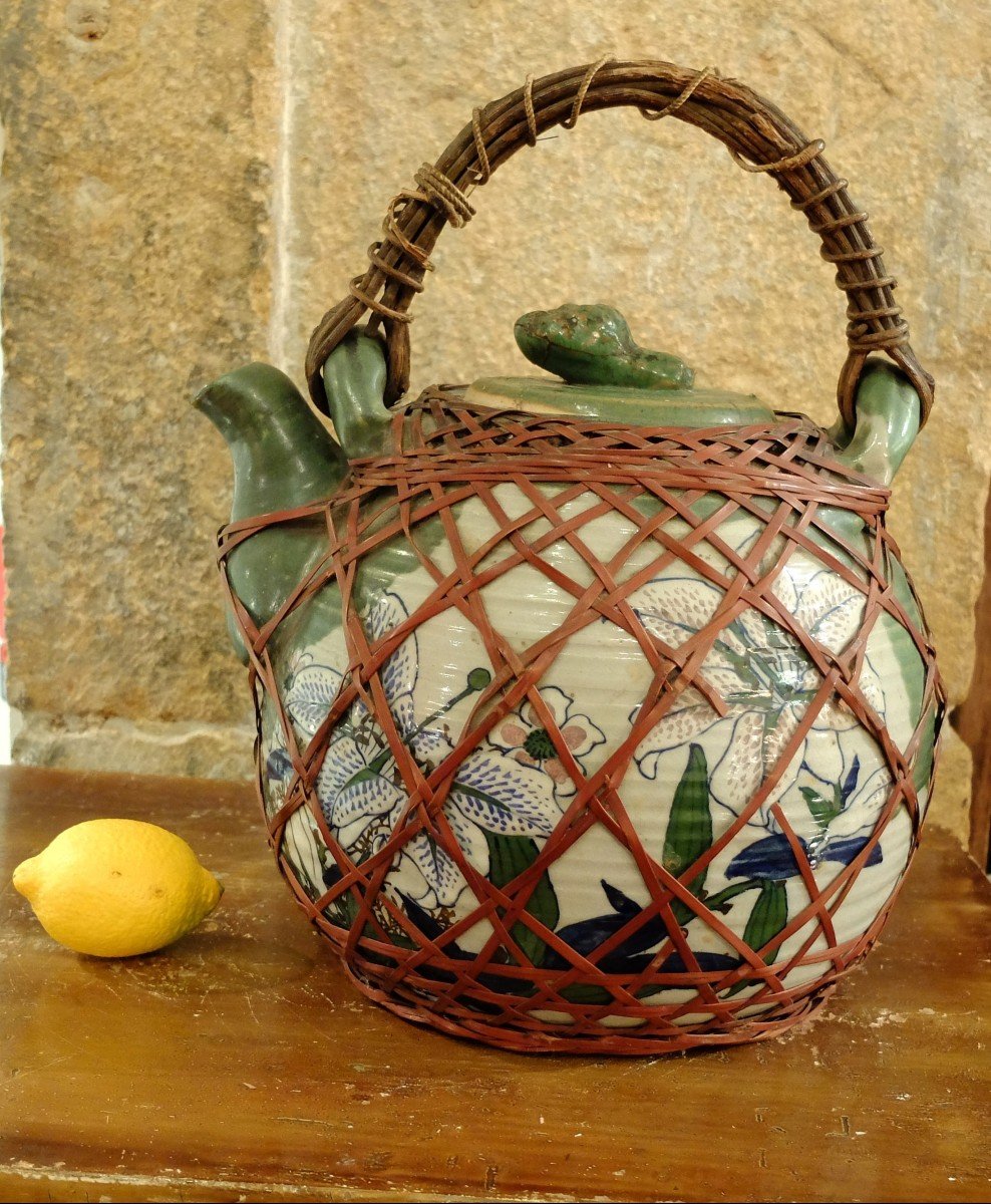 Very Large Porcelain Teapot Surrounded By A Basketwork Net. Japan. Late 19th Century.